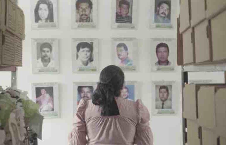 Yuli Velázquez, representante legal de la organización ambientalista FEDEPESAN, mira las fotos de defensores asesinados en Barrancabermeja, Colombia. $!Yuli Velázquez, representante legal de la organización ambientalista FEDEPESAN, mira las fotos de defensores asesinados en Barrancabermeja, Colombia.