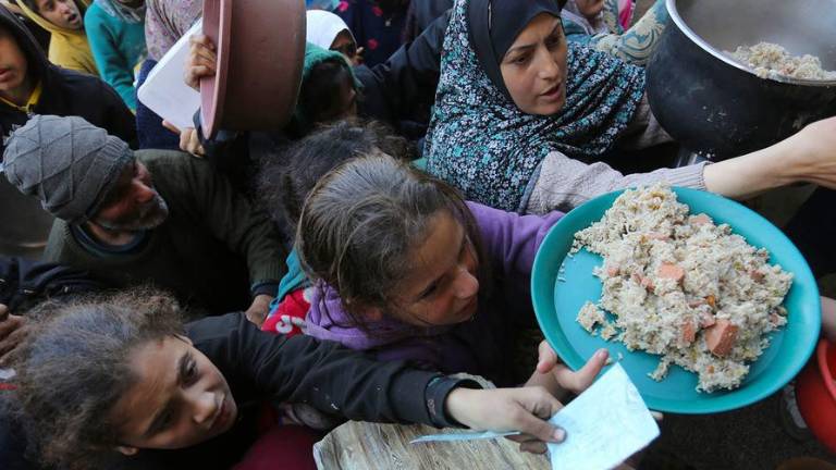 La gente de Gaza intenta desesperadamente conseguir comida en un punto de distribución de UNRWA.