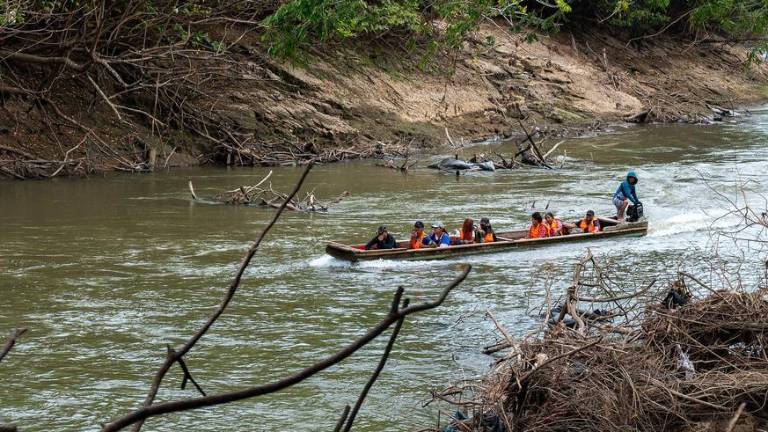 Niños migrantes cruzan un río en una embarcación en Panamá.