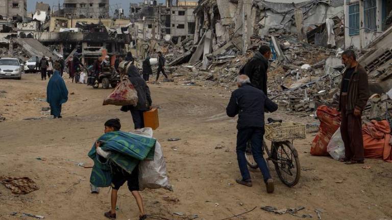 Varias personas transportan sus pertenencias por Jan Yunis, en el sur de la Franja de Gaza.
