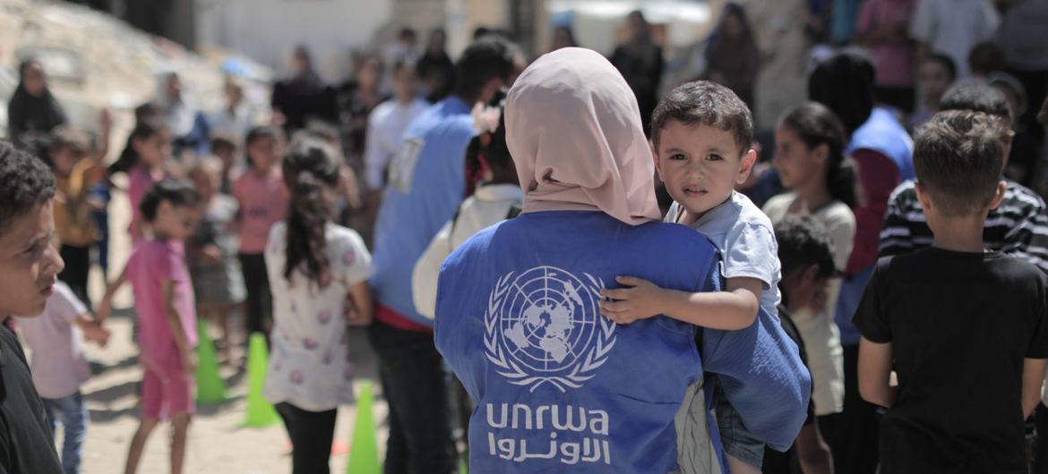 $!Una trabajador de UNRWA lleva a un niño en Gaza.