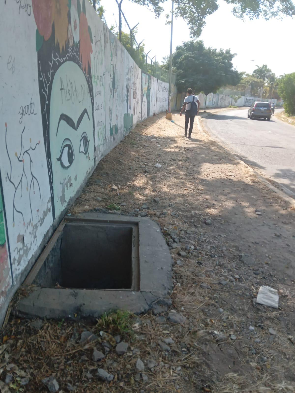 $!En la banqueta de la calle Zeus, pegado a la barda del CBTIS 51 está este registro sin tapadera, que en la noche aumenta el peligro de accidente.
