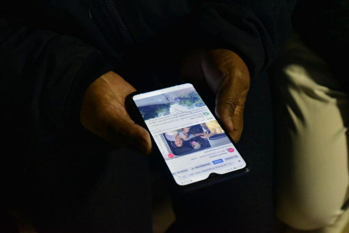 $!Migrantes miran las noticias en un celular.