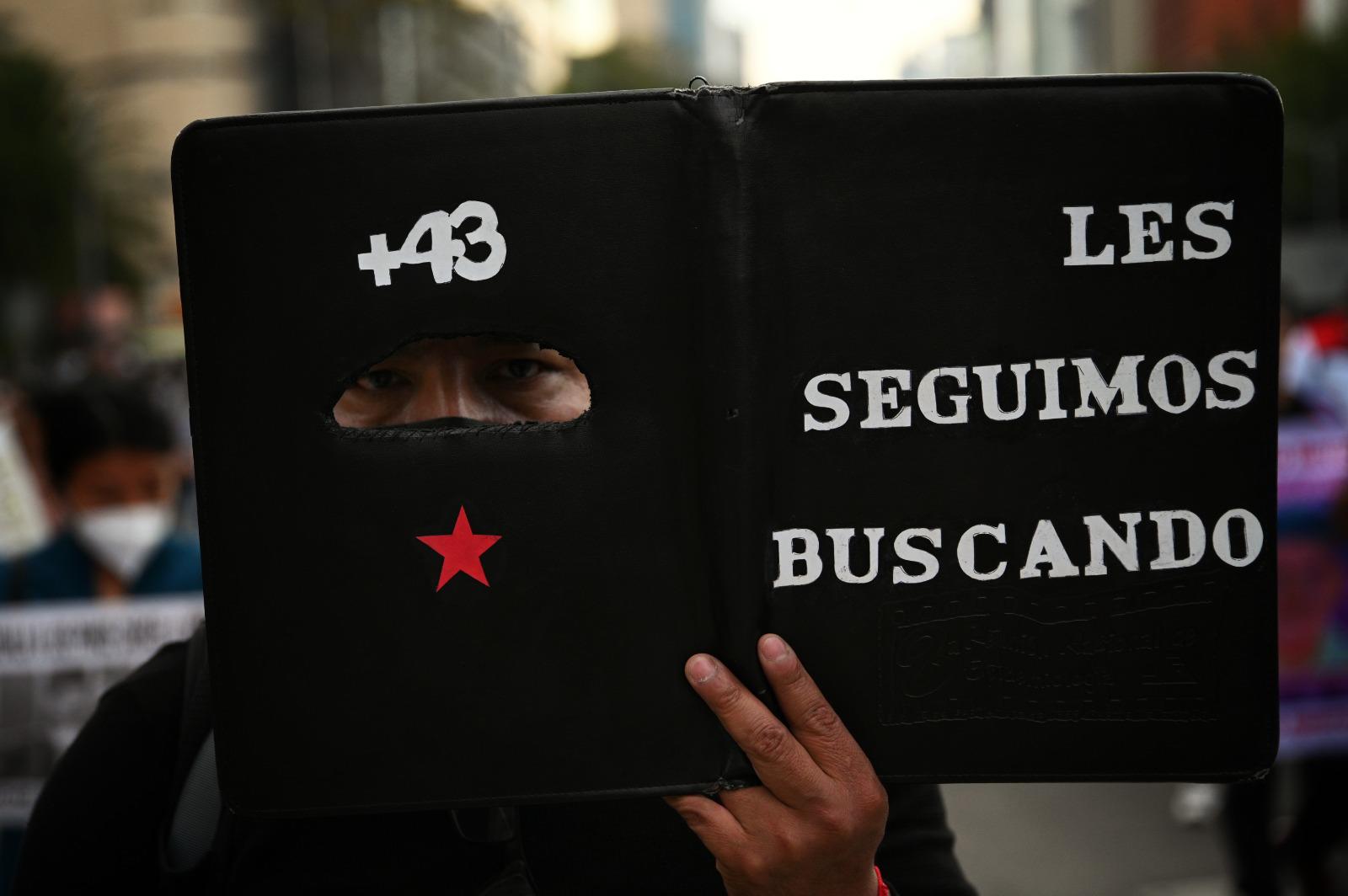 $!Un participante en la marcha organizada hace dos años en la Ciudad de México para conmemorar el séptimo aniversario de la desaparición de los jóvenes.