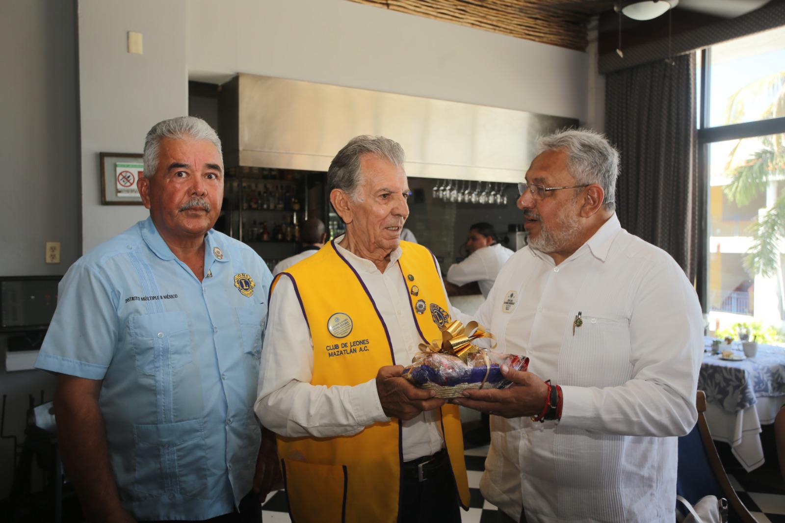 $!Arturo Martínez recibe un obsequio de manos de Wilevaldo Guardado Muñoz, presidente actual del Club de Leones de Mazatlán y José Luis Olivares Rodríguez.