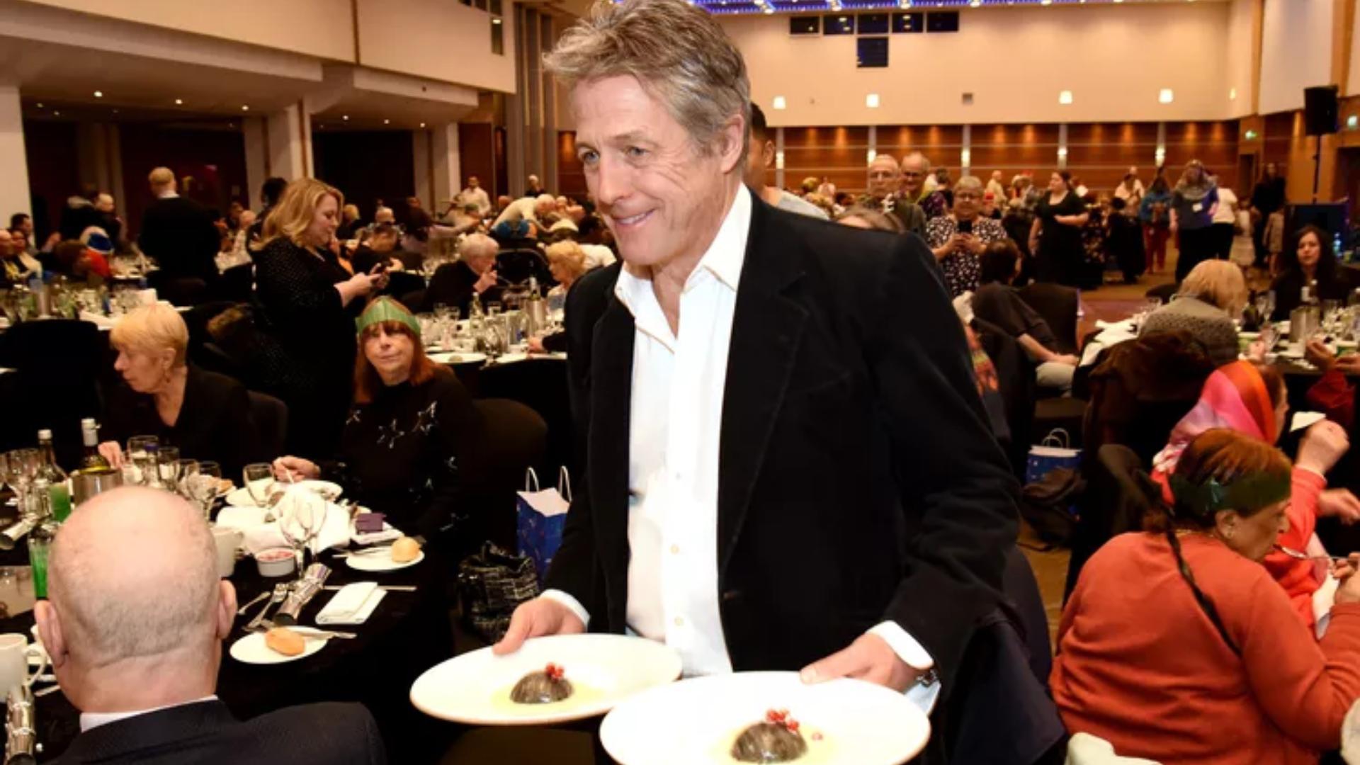 $!Hugh Grant sirve más de 500 platillos de comida a personas de bajos recursos