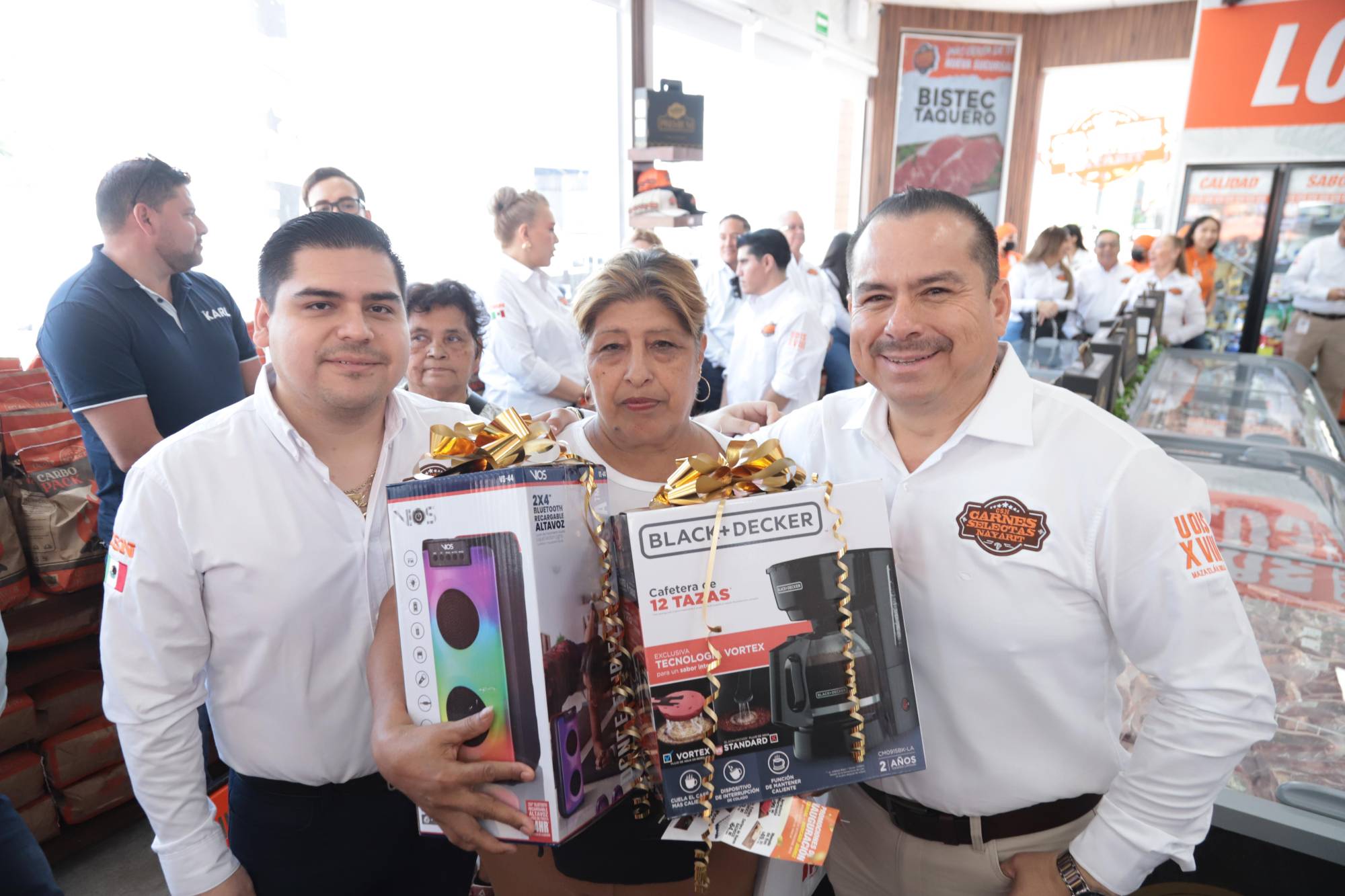 $!Julio y Julián Aguillón hacen entrega de unos premios a la primera clienta de la sucursal, la señora Yolanda Arce.
