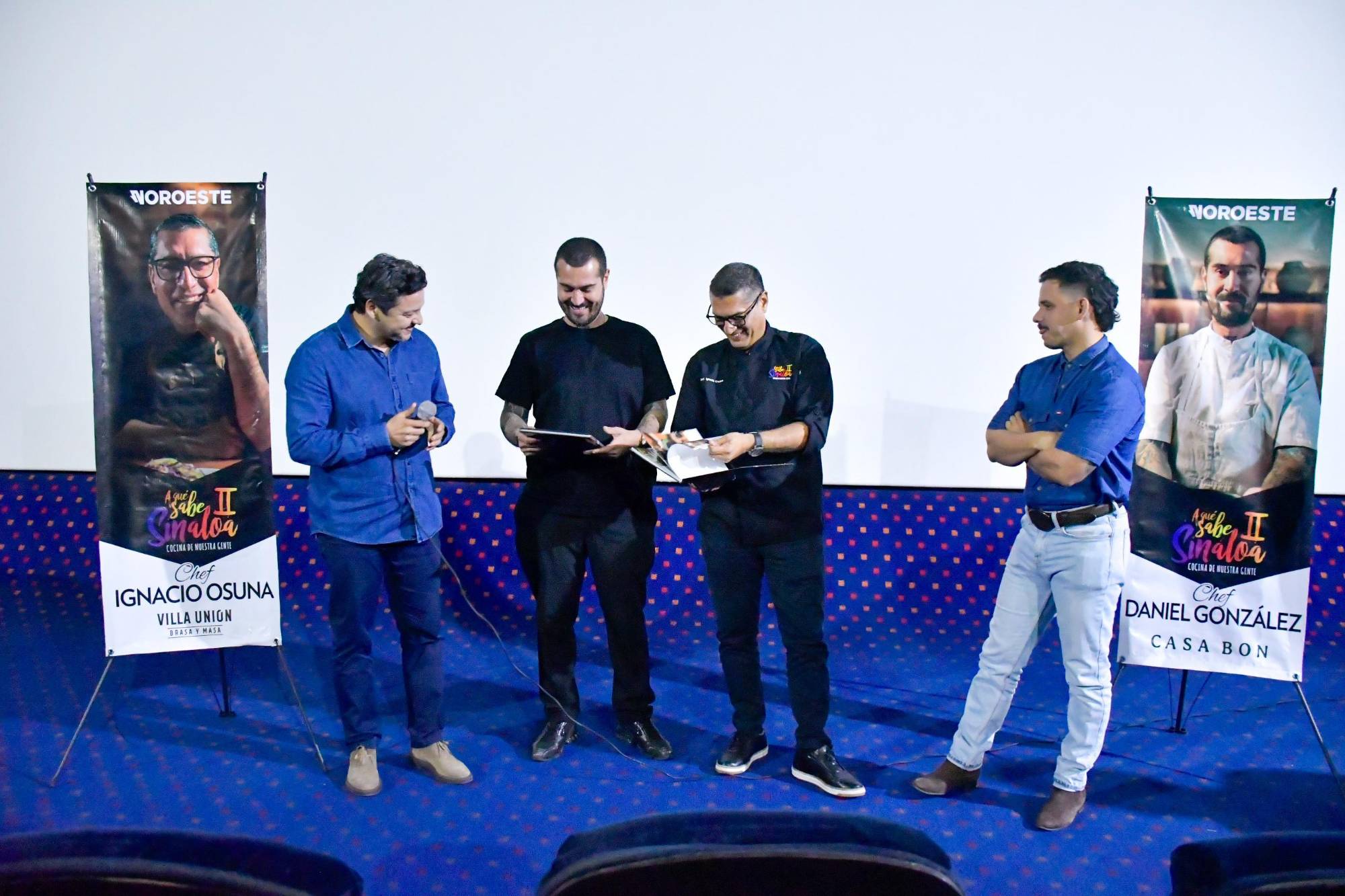 $!Durante la proyección, ambos chefs reciben el recetario oficial de A qué sabe Sinaloa II.