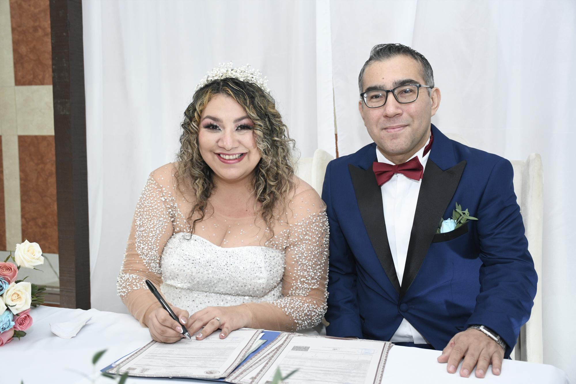 $!Los novios felices al firmar el acta de matrimonio.