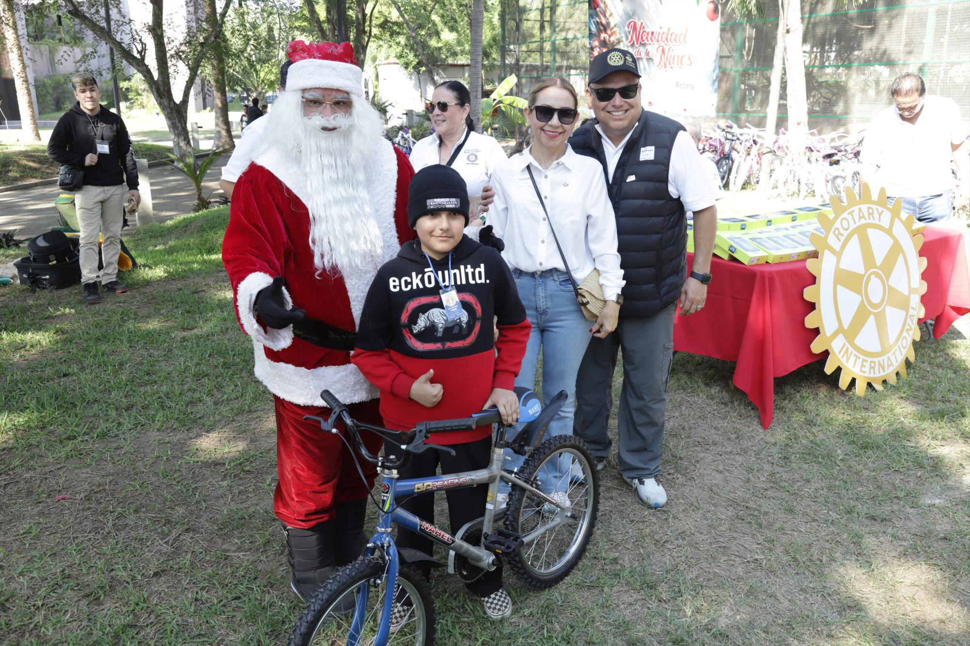 $!Tadeo Jiménez Gándara recibe una bicicleta de parte de Santa Clos, entregan Miguel Ángel López y su esposa Sofía López de López.