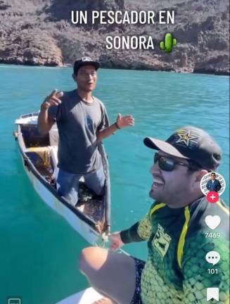 Julión Álvarez recibe un plato con almejas chocolatas en la playa “El Acuario”, en San Carlos, en Guaymas, Sonora