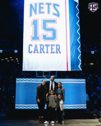 Vince Carter y su familia posan junto al jersey retirado.