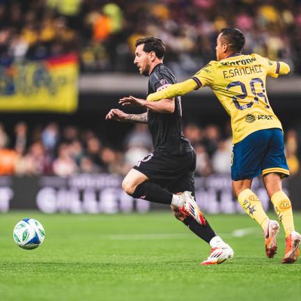 Erick Sánchez intenta detener a Lionel Messi.