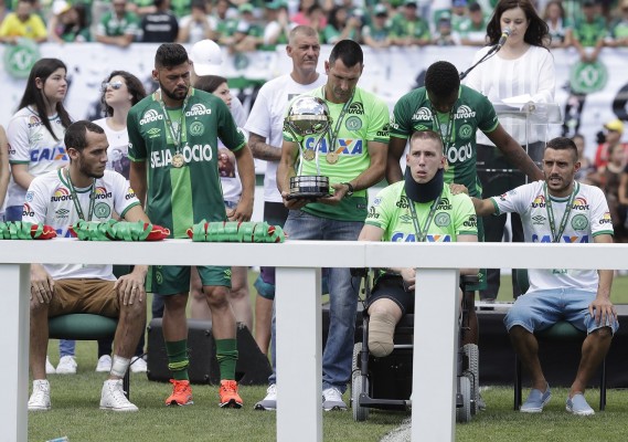 Los tres jugadores sobrevivientes muestran la Copa Sudamericana.