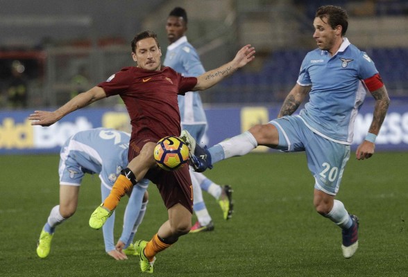 Francesco Totti y Lucas Biglia disputan el balón.
