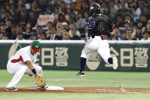 Efrén Navarro atrapa el tiro antes que Ryosuke Kikuchi alcance la primera base.