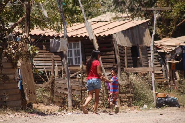 Una mujer camina con un niño en una invasión.