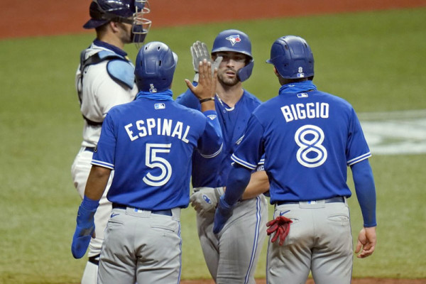 Randal Grichuk es recibido por sus compañeros tras dar su jonrón de tres carreras.