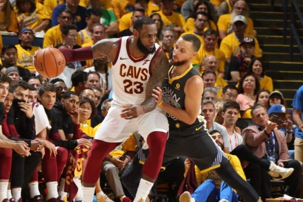 Stephen Curry (der.) en la marca a LeBron James.