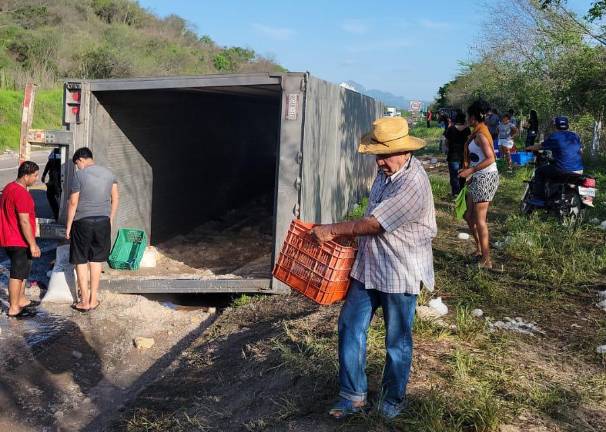 Decenas de personas se llevaron el contenido que transportaba el tráiler volcado.