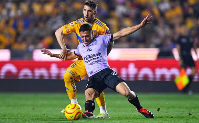 Fernando Gorriaran y Andrés Montaño forcejean en busca de la posesión del balón.