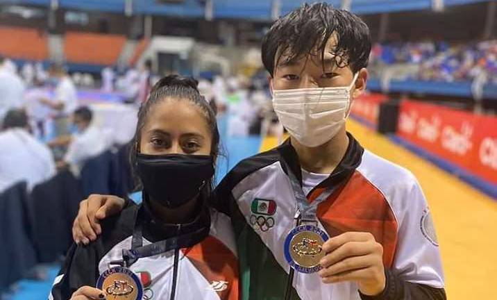Alma Aritzu Cisneros y Hayato Yoshii muestran sus medallas.
