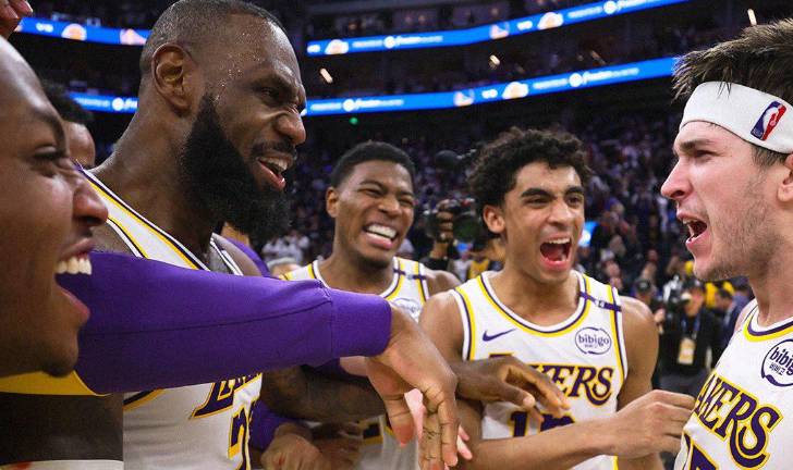 LeBron James y sus compañeros felicitan a Austin Reaves tras lograr el canasto del triunfo.
