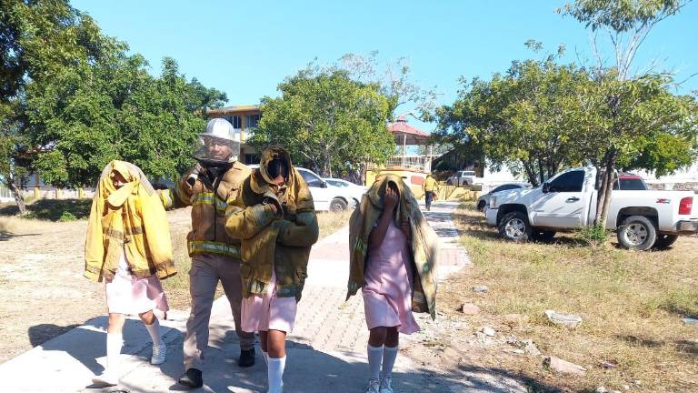 Bomberos brindan atención a los alumnos afectados.