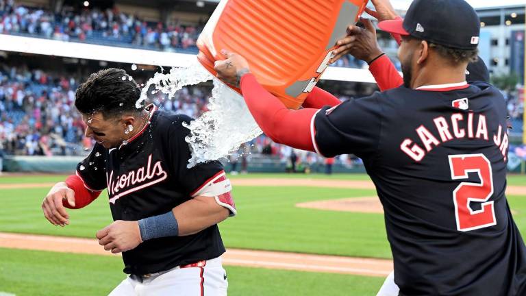 Joey Meneses es felicitado por Luis García Jr. tras definir el encuentro en favor de los Nacionales de Washington.