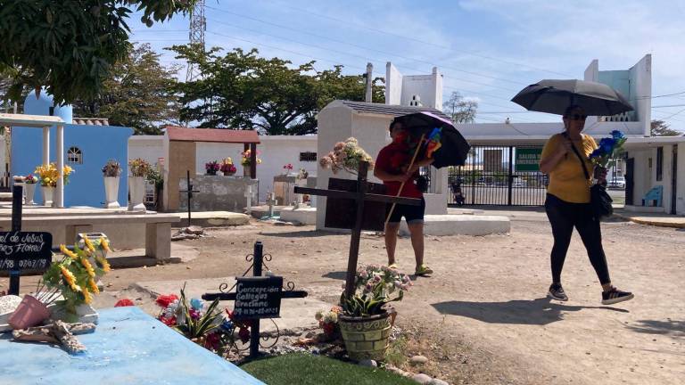 Los familiares se dieron su tiempo para limpiar y arreglar la tumba de sus padres.