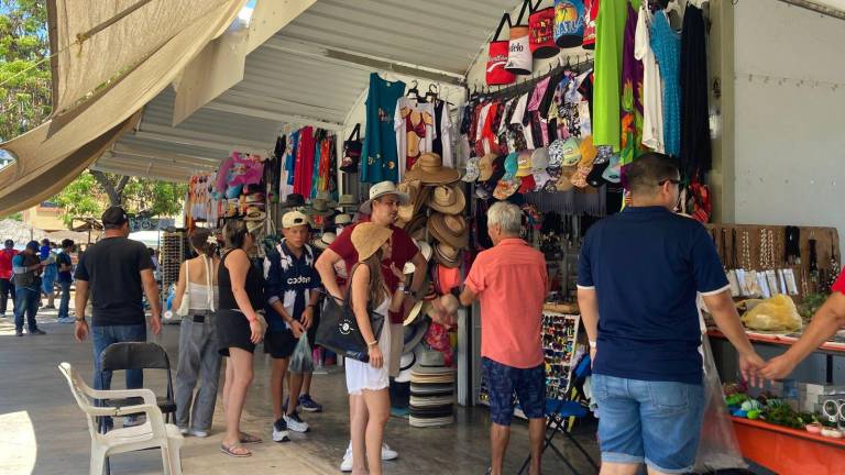 Vendedores de artesanías y artículos turísticos esperan que las ventas mejoren con el flujo turístico de agosto en el puerto.
