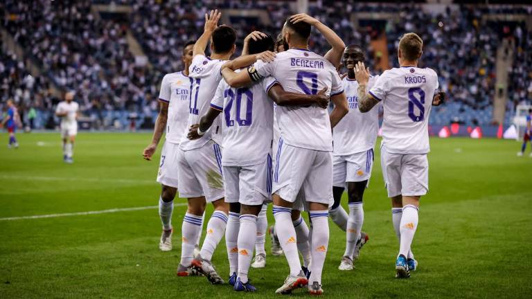 Karim Benzema es felicitado tras anotar ante Barcelona.