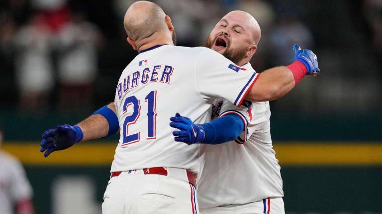 Jake Burger es felicitado por Rowdy Tellez tras la victoria de los Rangers.