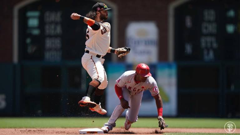 Brandon Crawford se dispone a tirar a la primera base para buscar el doble play.