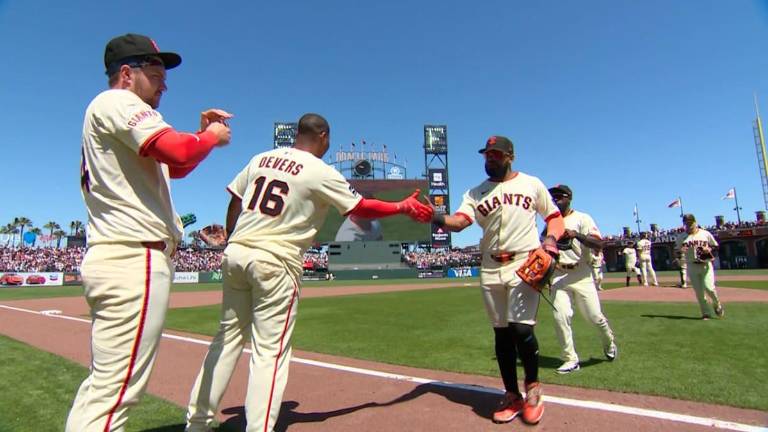 Rafael Devers felicita a Heliot Ramos, luego que entre ambos definieran el triunfo de los Gigantes.