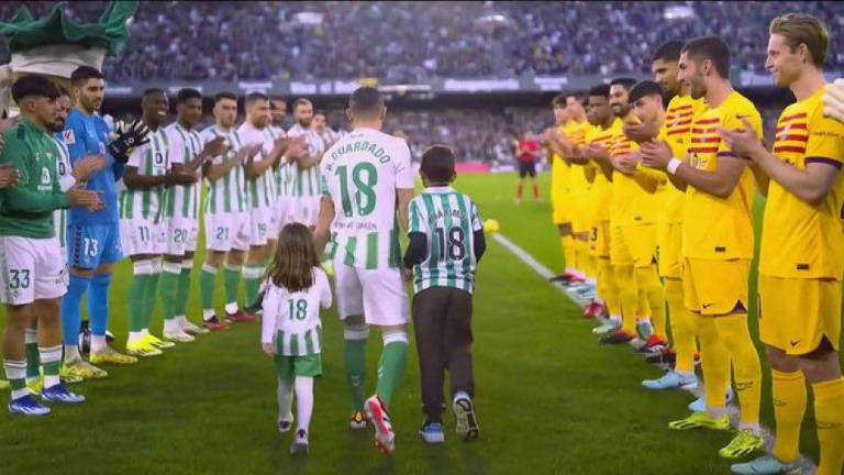 Jugadores del Betis y Barcelona hacen el pasillo.