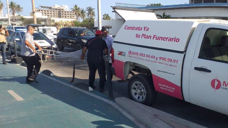 El personal de la funeraria recoge el cuerpo de la mujer.
