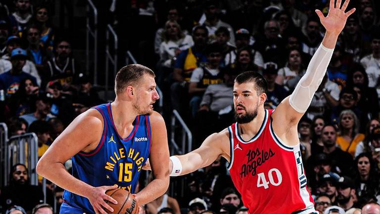 Nikola Jokic busca superar la defensiva de Bogdan Bogdanovic.