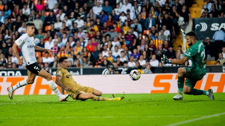 Robert Lewandowski se estira en el suelo para anotar.