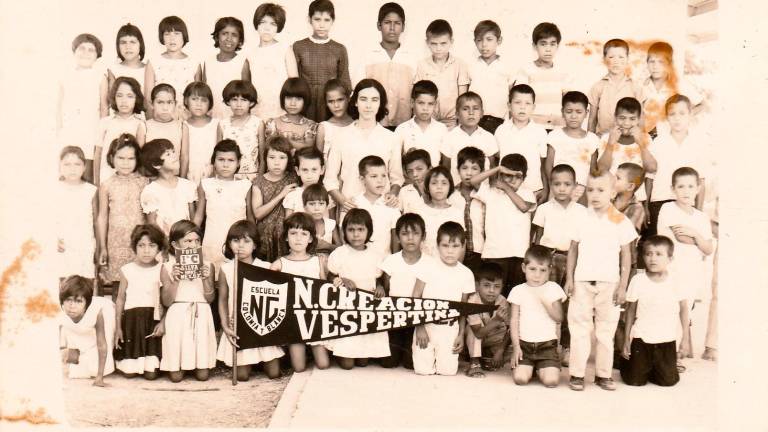 La profesora Amparo Ochoa, flanqueada por sus alumnosde primer grado, de la Escuela Primaria Nueva Creación.