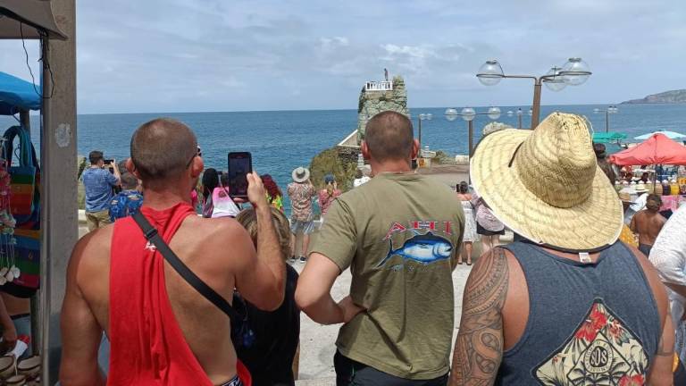 Cruceristas que llegaron este miércoles a Mazatlán disfrutan el espectáculo del clavadista.