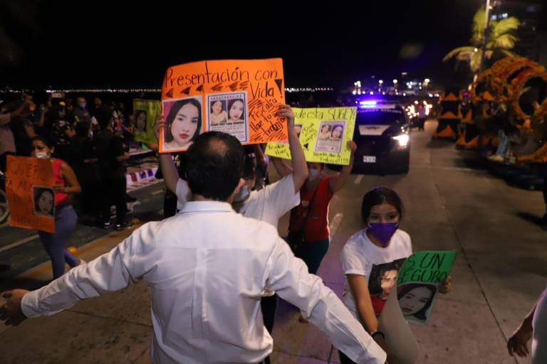 Mujeres protestan durante desfile del Día de Muertos en Mazatlán; empleado del Ayuntamiento les bloquea el paso