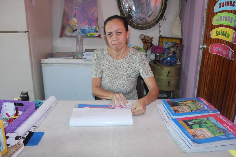 Lucía, con paciencia, en el regreso a clases hace del forrado de libros un oficio