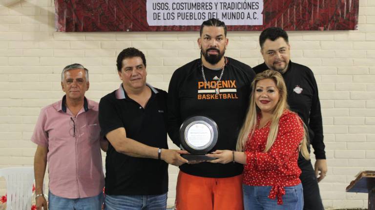 Horacio Llamas Grey recibe un reconocimiento de manos de autoridades municipales.