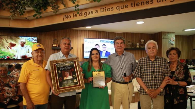 La familia del homenajeado recibe el reconocimiento.