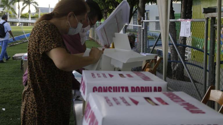 Una mujer emite su voto en una casilla en Culiacán.