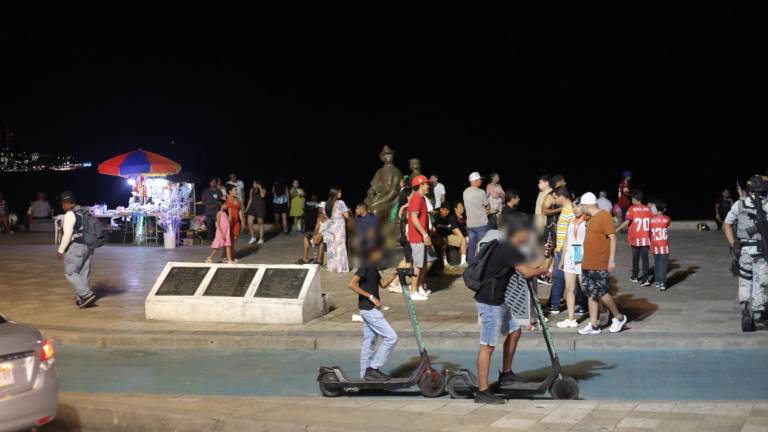 Usuarios de scooter en la ciclovía del malecón de Mazatlán durante la noche del domingo.