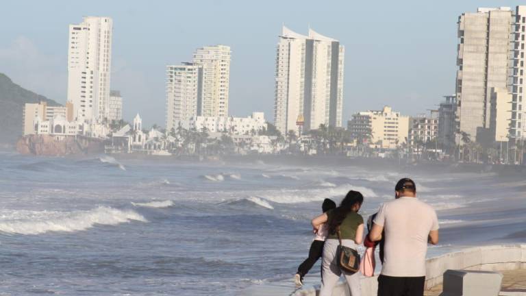 Una familia recorre el paseo costero.