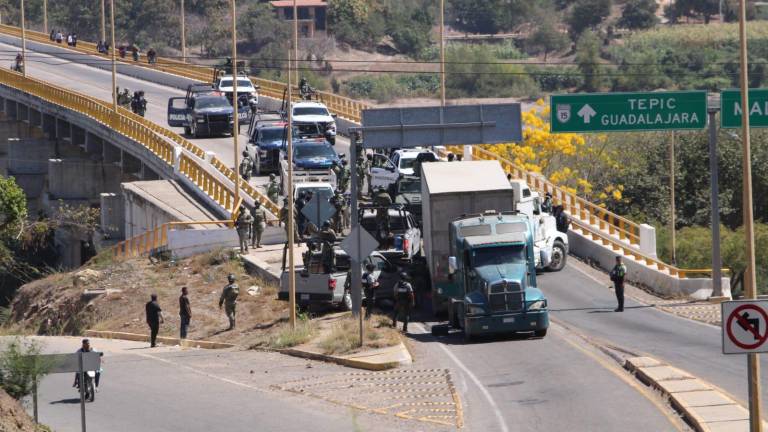 Personal de diferentes corporaciones retiran los vehículos que bloqueaban el paso en el puente sobre el río Baluarte.