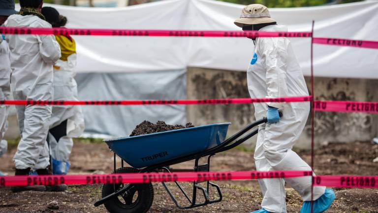 Personal forense trabaja en la extracción de cuerpos en la fosa común del panteón 21 de Marzo en Culiacán.